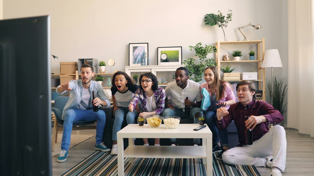 group of friends on couch watching tv