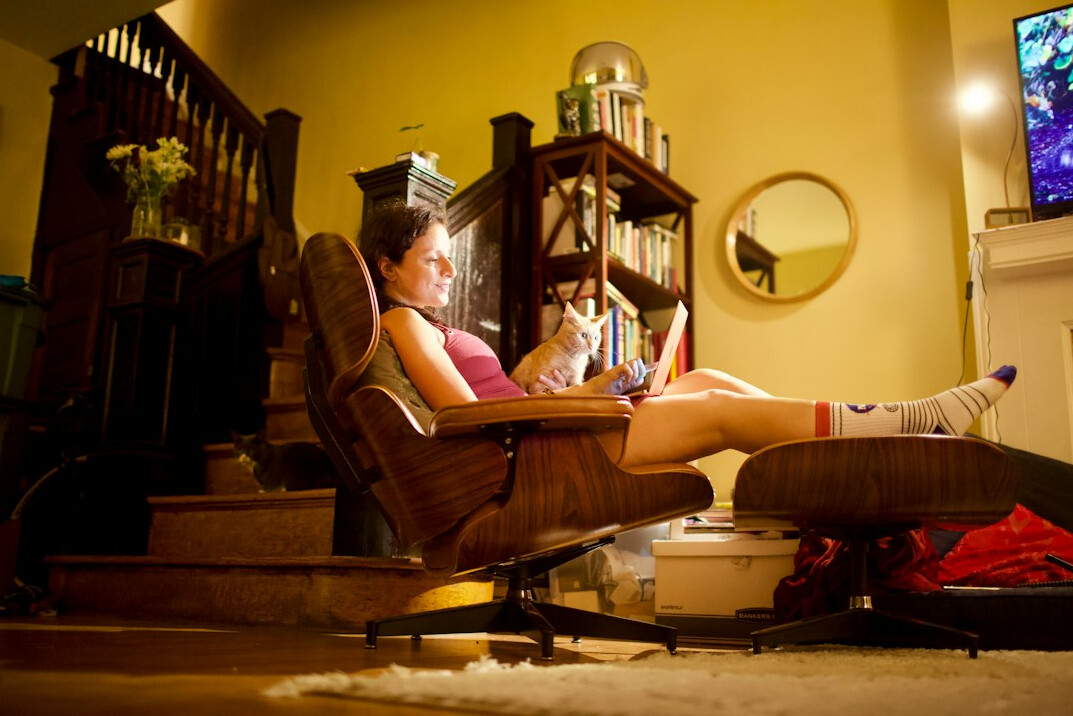 Portuguese woman sitting in a cozy living room watching an old television set